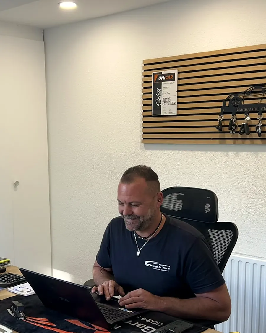 Nicolas Emery à son bureau, sous le panneau à clés du garage