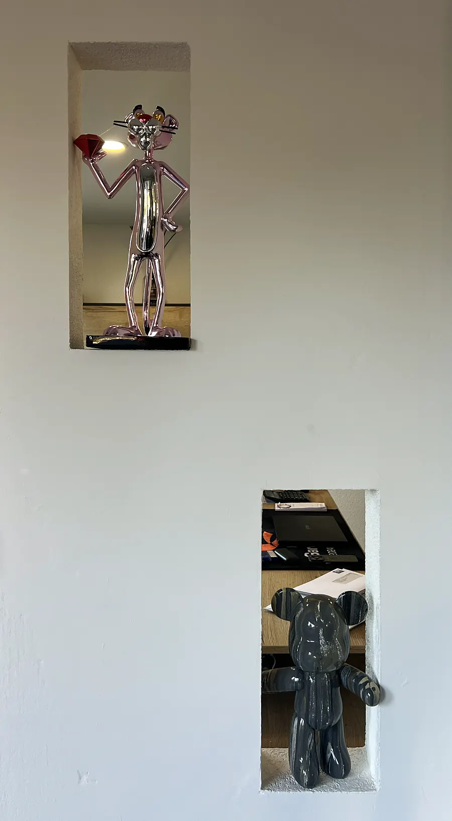 Figurines chromées dans les niches du mur